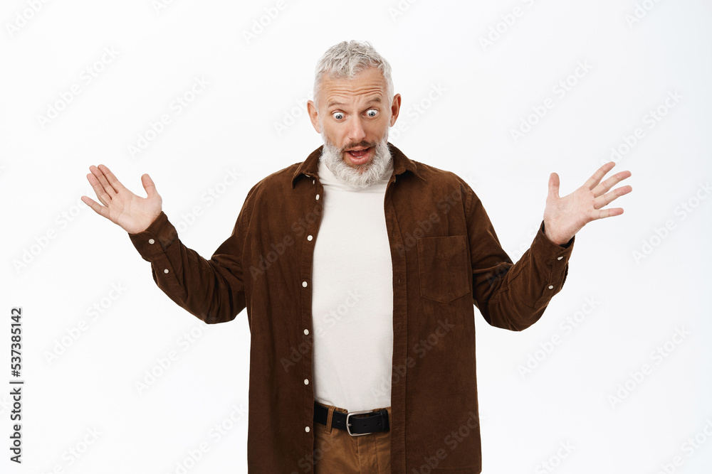 Amazed old man, showing smth big, spread hands sideways and staring impressed at camera, standing over white background Amazed old man, showing smth big, spread hands sideways and staring impressed at camera, standing over white background