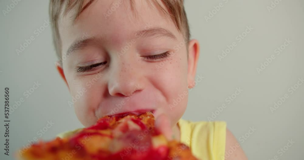 Portrait child happy little boy eagerly eat delicious pizza,smiling child looking at camera at home eating Italian pizza,cute kid child with pretty face eagerly. Concept happy childhood Portrait child happy little boy eagerly eat delicious pizza,smiling child looking at camera at home eating Italian pizza,cute kid child with pretty face eagerly. Concept happy childhood