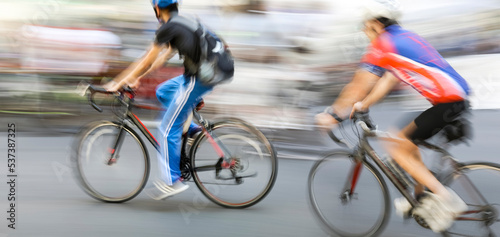 Blurred silhouettes of cyclists on a city street