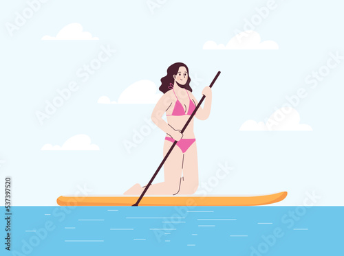 Young woman is on her knees in swimsuit on sup. Stand up paddle. © Anastasiia