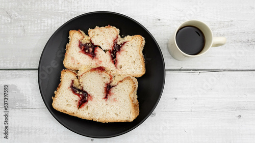 Two slices of traditional German red berry cuca on a black plate with coffee on the side. A delicacy from the Silesian region between Poland and Germany quite popular for breakfast and afternoon.