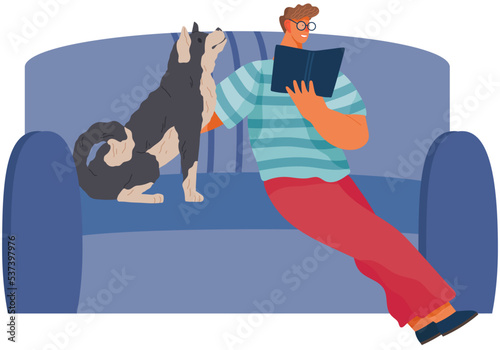 Young man reading book and petting dog on cofa. Smiling male character having rest with puppy at home. Guy with cute pet, domestic animal spending time on couch. Relax, leisure or education concept