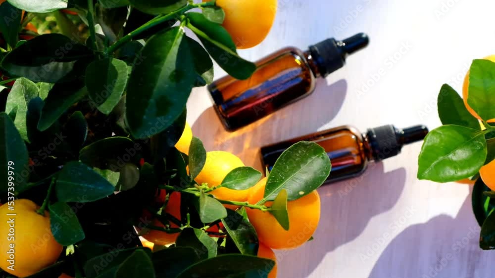 tangerine essential oil.Citrus oil. bottles with oil on a white wood