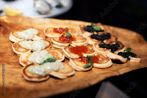 a lot of pancakes with red, black and white caviar