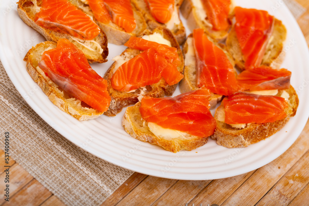Closeup of tasty sandwiches with bread and fresh sliced salmon fillet