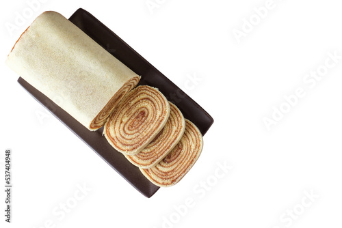 Sliced bolo de rolo (roll cake) on a brown plate. Brazilian traditional sweet (PNG). photo