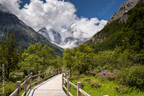 Horizontal image of the wooden pathway in Yading Nature Reserve, Daocheng County, Sichuan, China. Blue sky with clouds, copy space for text