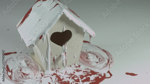 Red and White Paint Pours Onto Wooden Birdhouse 4K photo