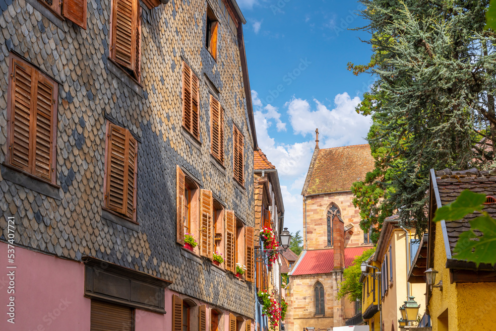 Obraz premium One of the many picturesque and colorful streets and alleys of half-timbered buildings in the medieval village of Ribeauville, France, in the Alsace wine region of Northeast France.