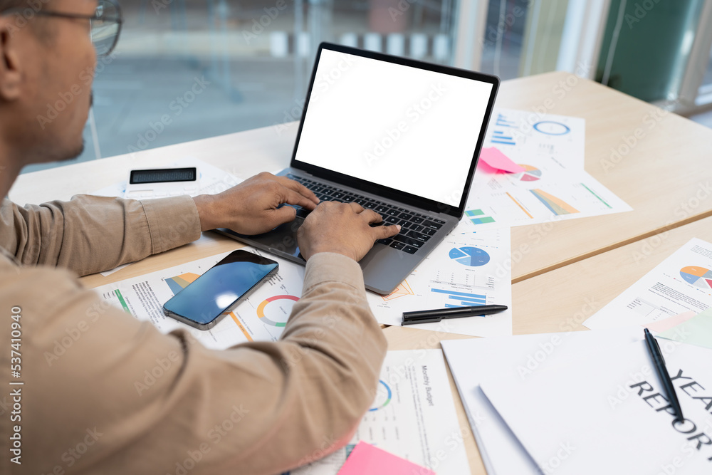 Asian entrepreneur making business plan while working on laptop with empty screen