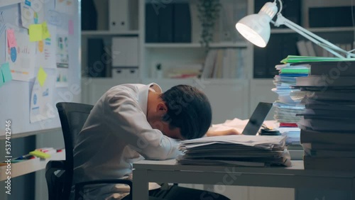 Exhausted Asian young businessman worker working on table in office. photo