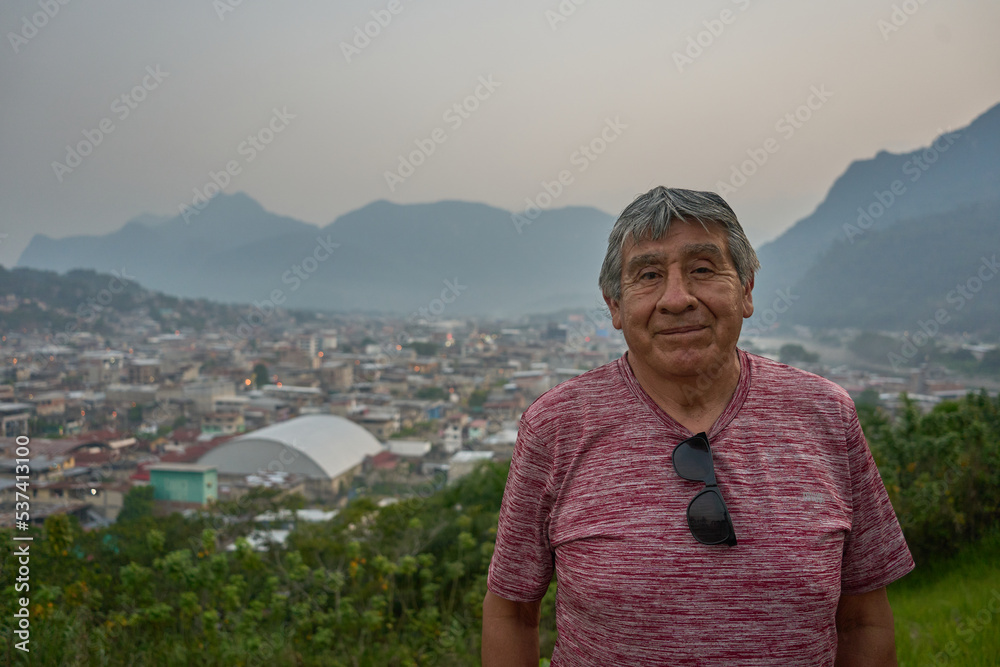 Senior person standing in front of a mountain in the Peruvian Jungle 