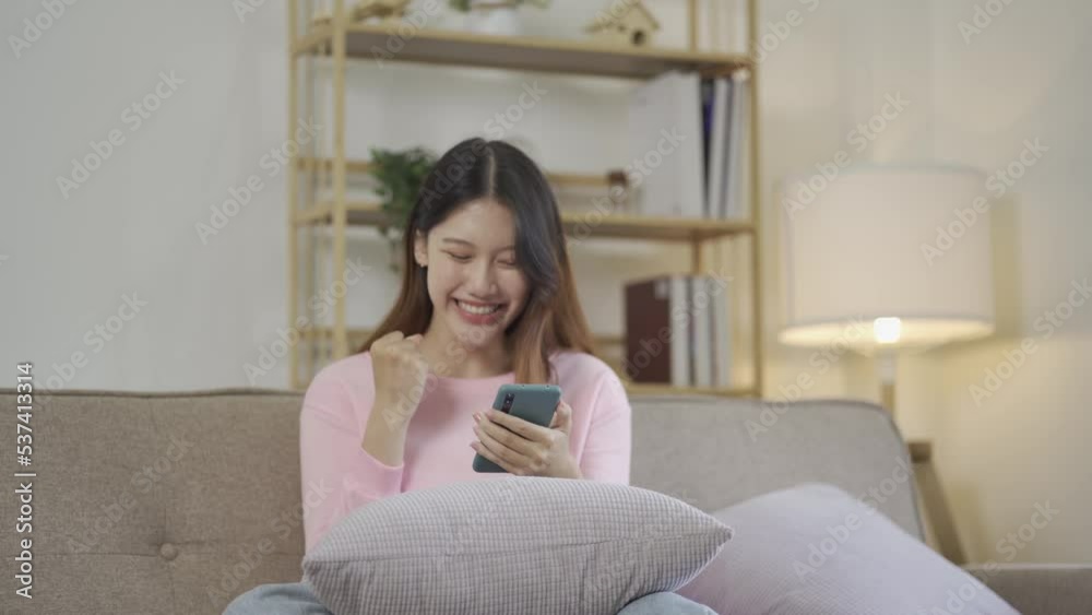 Social media, online and Asian women use smartphones on the couch at home. girl using the internet to play games online shopping and send a message on the phone
