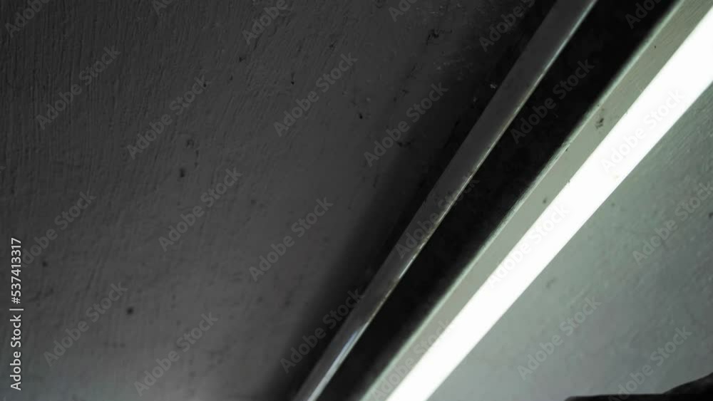 The inclusion of one of the two fluorescent lamps on the old lamp on the ceiling close-up. Long start-up of a gas-discharge light source