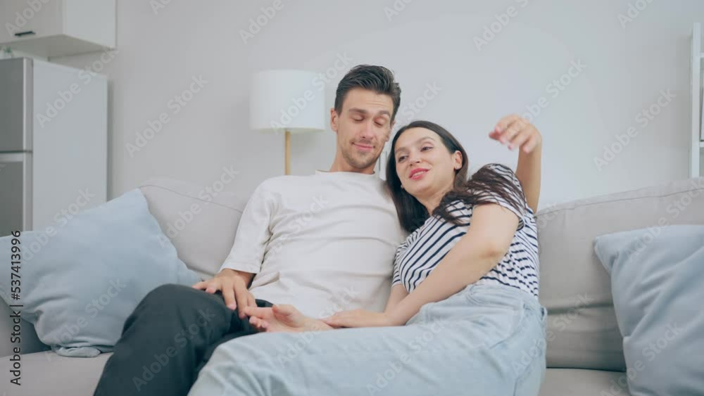 Caucasian young couple spend free leisure time together in living room. Caucasian young couple spend free leisure time together in living room.