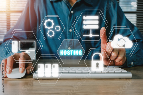 Web hosting concept, Man using computer and presses his finger on the virtual screen inscription Hosting on desk, Internet, business, Technology and network concept.