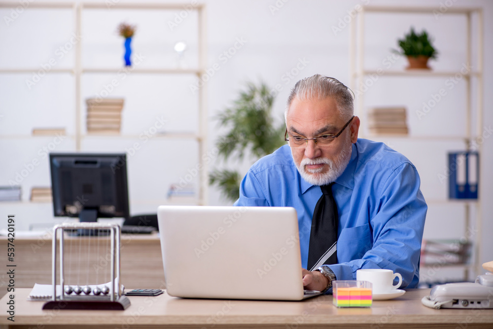 Old male employee working in the office Old male employee working in the office