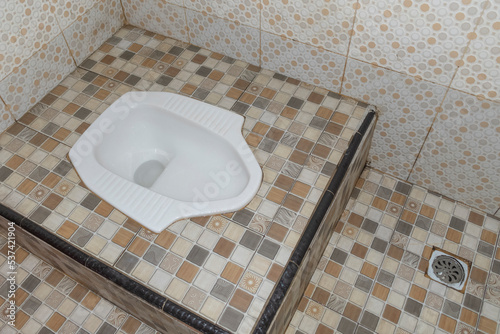 white squat toilet in bathroom. old style toilet. commonly used in asia photo