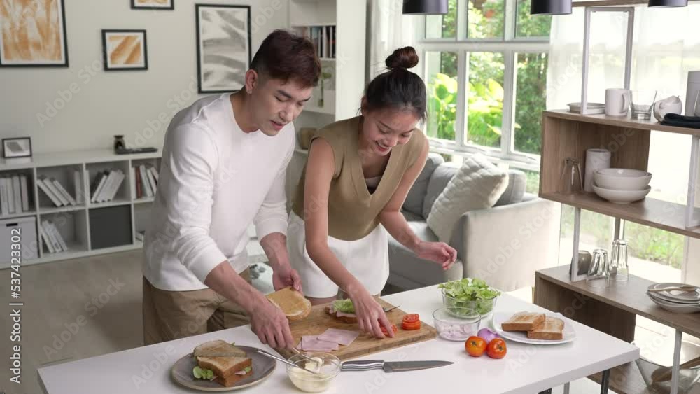 Romantic Asian couple is cooking on kitchen. Happy young man and young woman are having fun together while prepare food. Couple lifestyle concept. Romantic Asian couple is cooking on kitchen. Happy young man and young woman are having fun together while prepare food. Couple lifestyle concept.