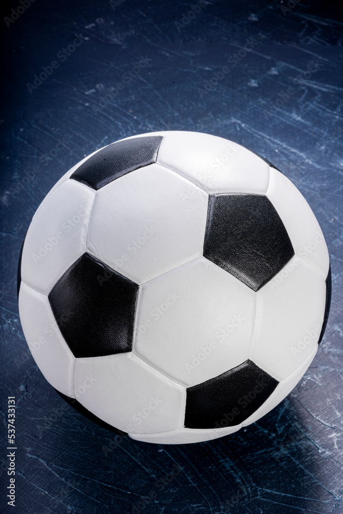 Naklejka premium Football ball or background sports equipment on dark wooden background. 
