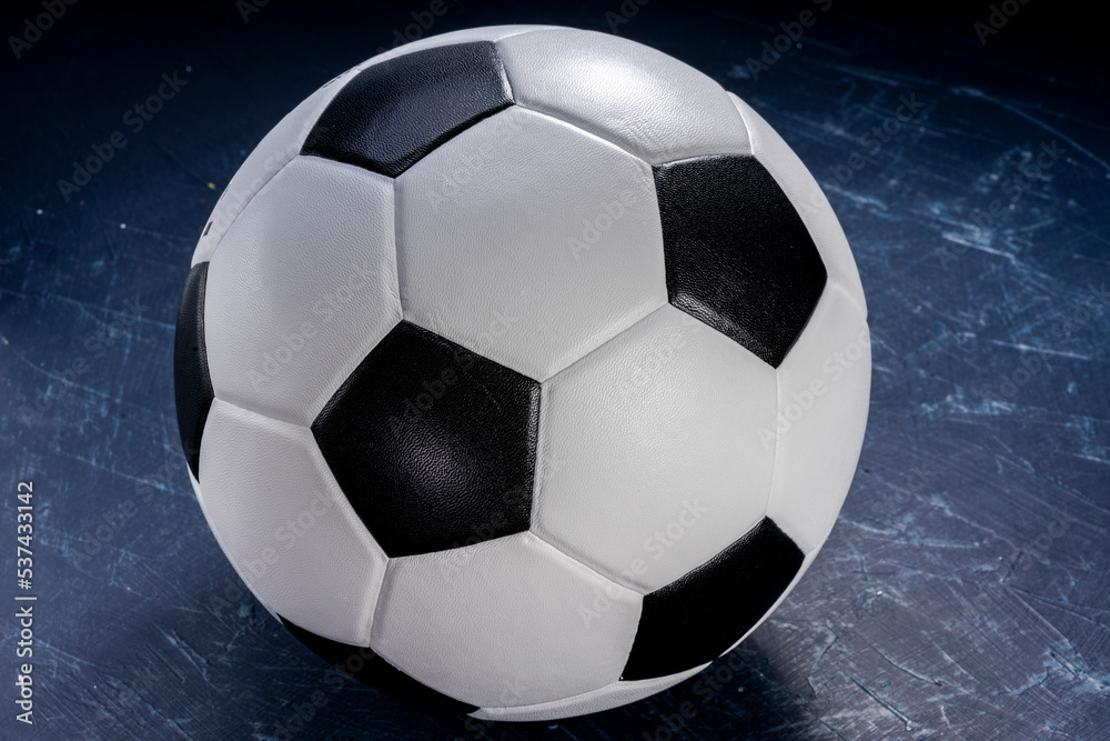 Naklejka premium Football ball on black background, Football ball sports equipment on dark wooden background.