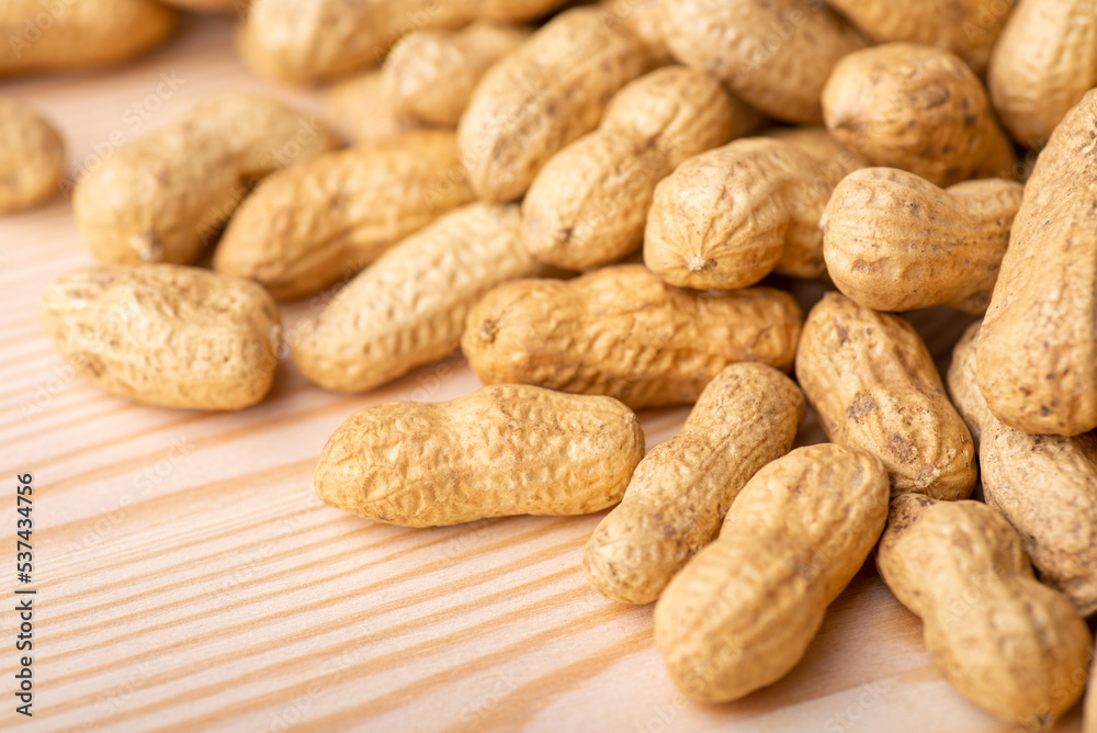 Close up shot of peanuts on wooden table. Golden peanut after roasting, fresh nuts Close up shot of peanuts on wooden table. Golden peanut after roasting, fresh nuts