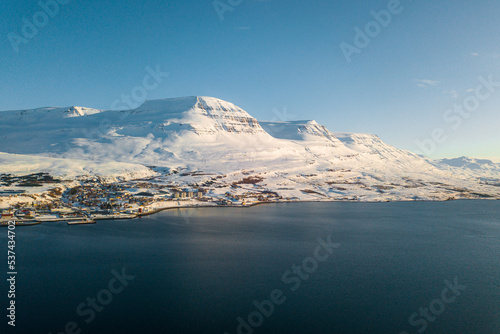 Along the way around Reydarfjordur , ports town close to the sea and snow mountain during winter sunny day at Reyðarfjörður , Fjord town on Eastern Coast of Iceland : 19 March 2020