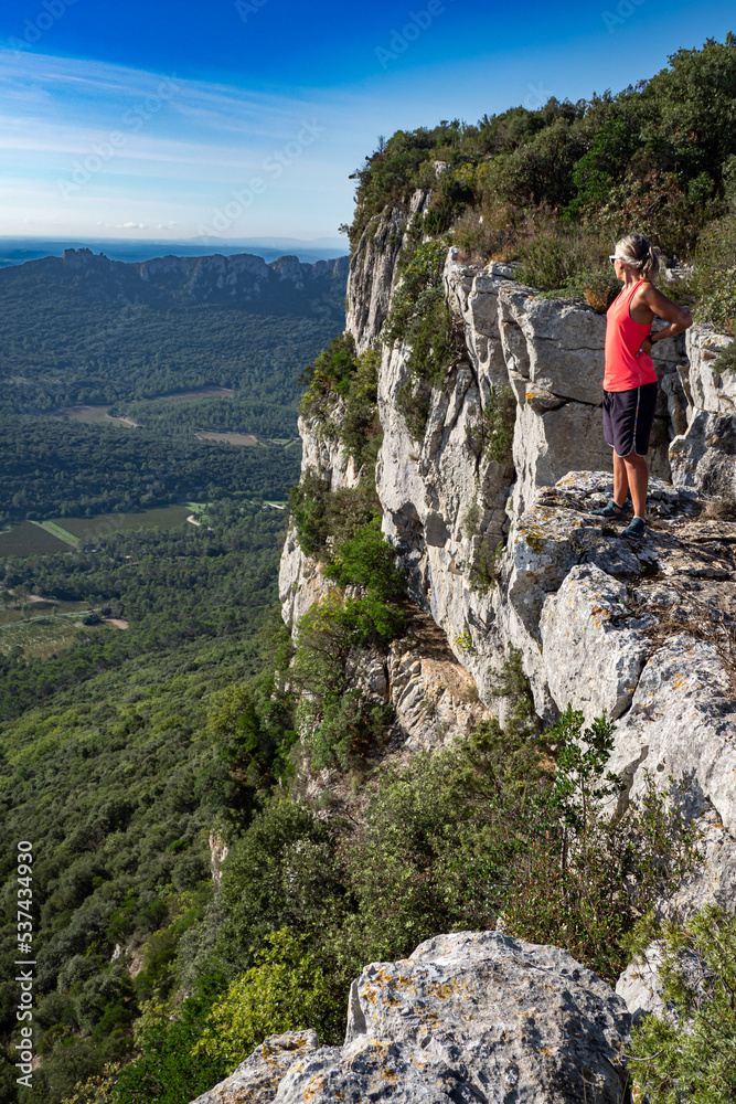 Female hiker stetching at view point while hiking the Pic saint Loup in the south of France