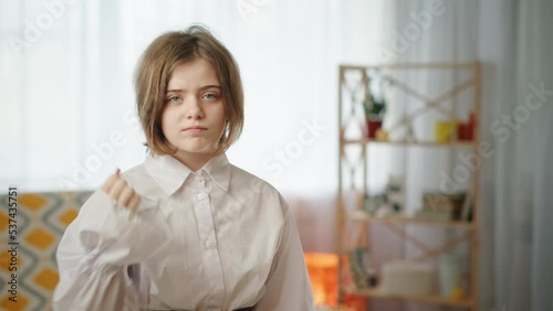 Menacing girl showing cutthroat gesture