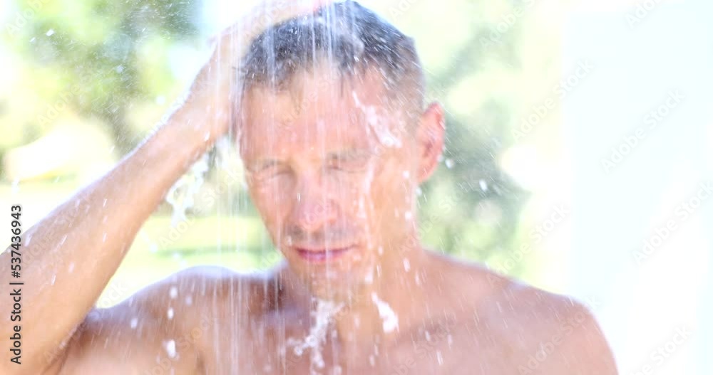 Handsome man enjoys being washed outdoors Handsome man enjoys being washed outdoors