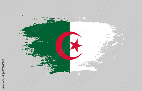 Grunge brush stroke with the national flag of Algeria on a white isolated background