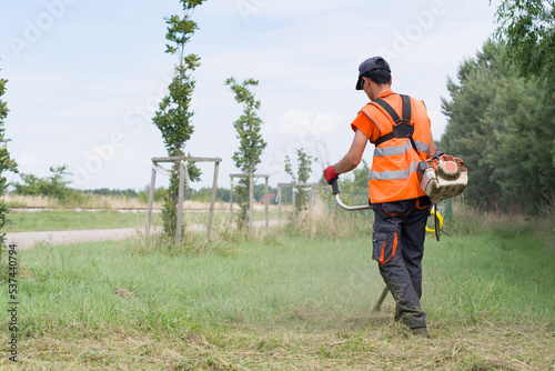 worker cutting grass