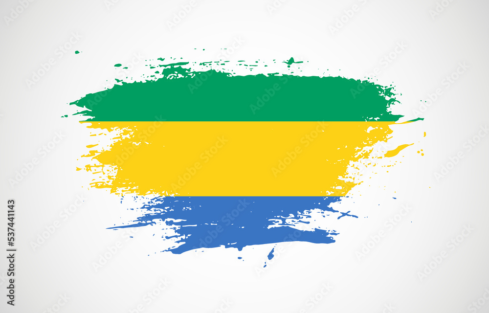 Obraz premium Grunge brush stroke with the national flag of Gabon on a white isolated background