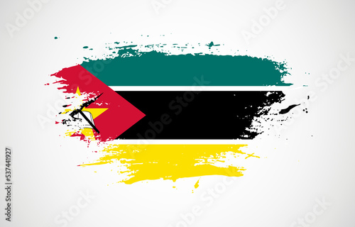 Grunge brush stroke with the national flag of Mozambique on a white isolated background