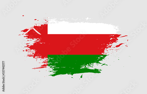 Grunge brush stroke with the national flag of Oman on a white isolated background