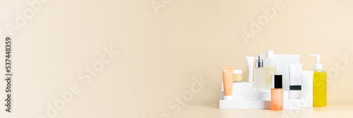 Skin care routine set. Different cosmetic product on geometric podiums o beige background.