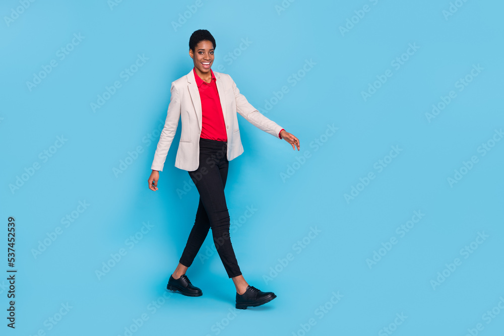 Full length profile portrait of confident person walking wear blazer isolated on blue color background