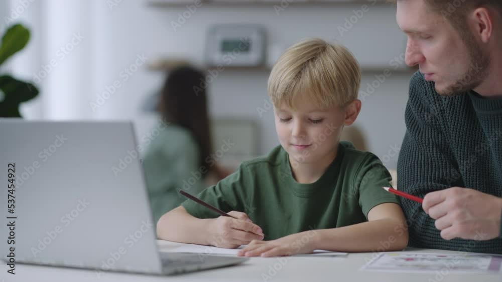 Mixed family at home. Father and child. dad helping son with school homework. Education and relationship, man teaching and boy learning. home schooling. Mixed family at home. Father and child. dad helping son with school homework. Education and relationship, man teaching and boy learning. home schooling.