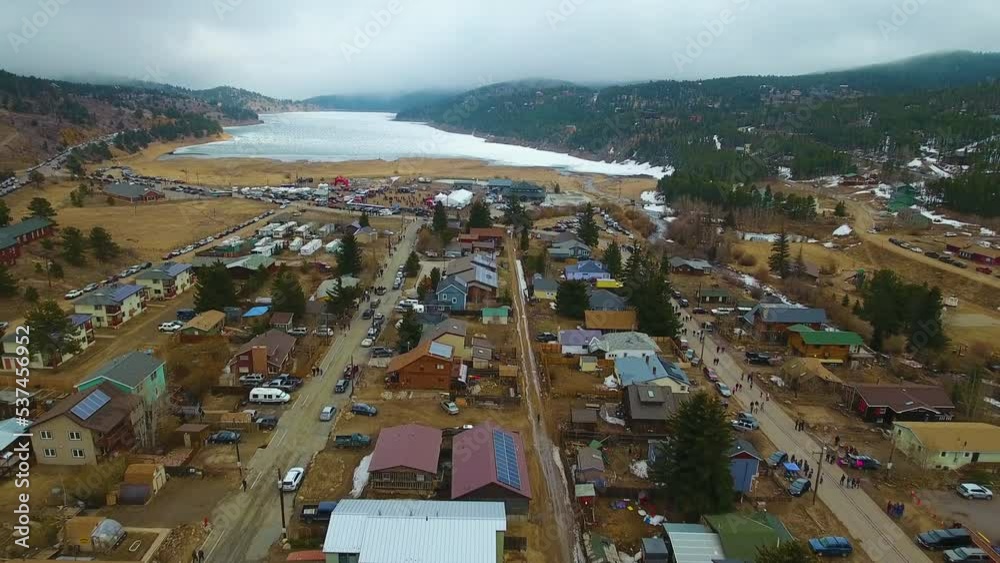 Drone footage of Barker Meadows Reservoir. Nederland Colorado. Frozen Dead Guy Days Festival. Through town to frozen lake