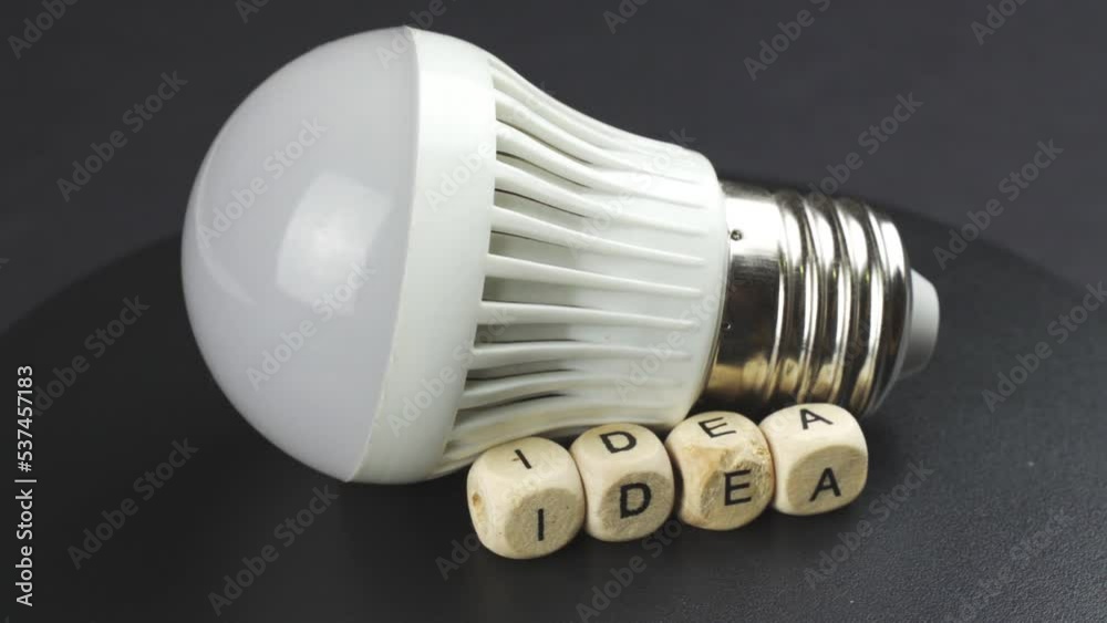 A lamp and cubes with the inscription -Idea, are spinning on a revolving table. Close-up. Business and education concept. A lamp and cubes with the inscription -Idea, are spinning on a revolving table. Close-up. Business and education concept.