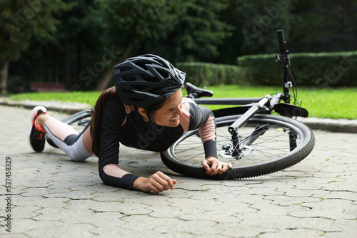 Young woman fallen off her bicycle in park