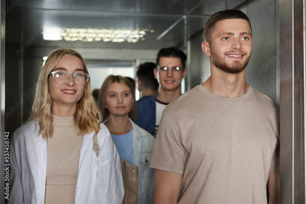 Obraz premium Group of young people in modern elevator