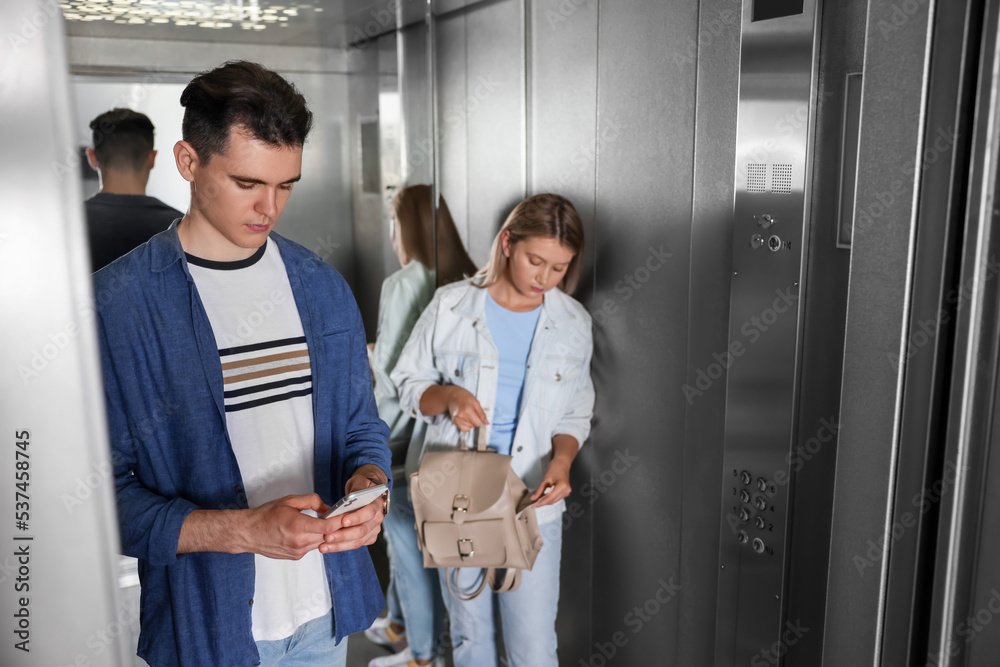Young people taking ride in elevator together Young people taking ride in elevator together