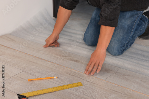 Professional worker installing new laminate flooring, closeup