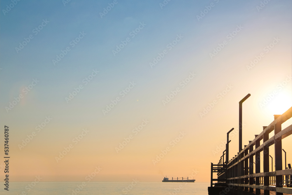 Picturesque view of pier near sea with boats at sunrise