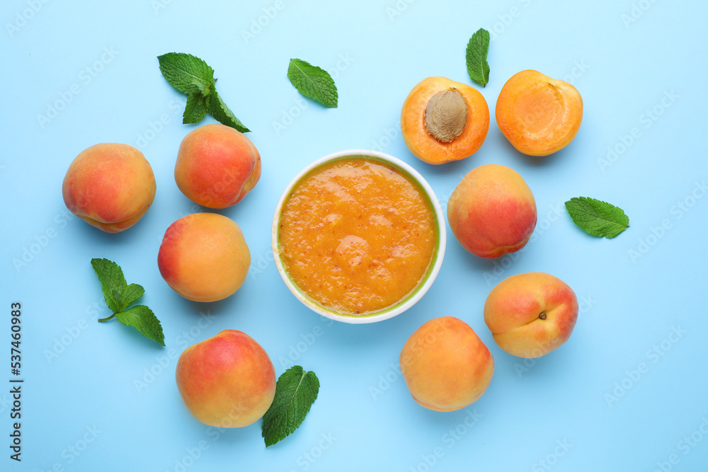 Apricot puree in bowl and fresh fruits with mint on light blue background, flat lay Apricot puree in bowl and fresh fruits with mint on light blue background, flat lay
