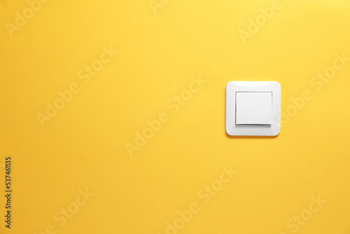 Modern plastic light switch on orange background. Space for text