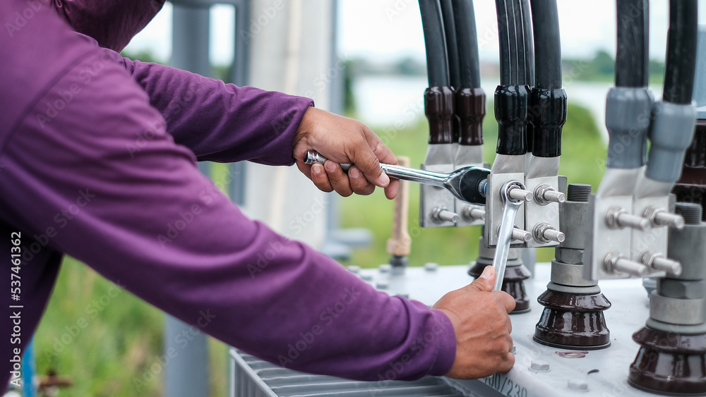 Two electrician builder workers installing highvoltage cable.Hydraulic