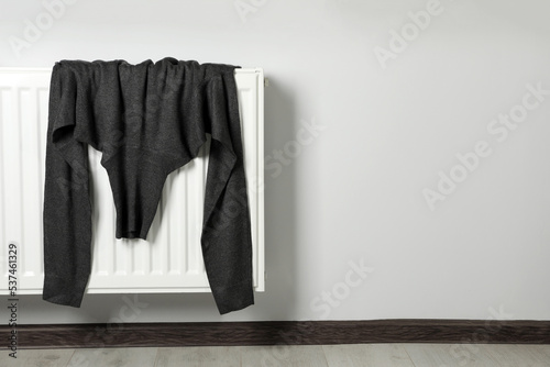 Wallpaper Mural Grey turtleneck sweater on heating radiator indoors. Space for text Torontodigital.ca