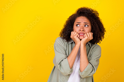 Photo of sad wavy millennial lady look empty space wear grey shirt isolated on yellow color background photo